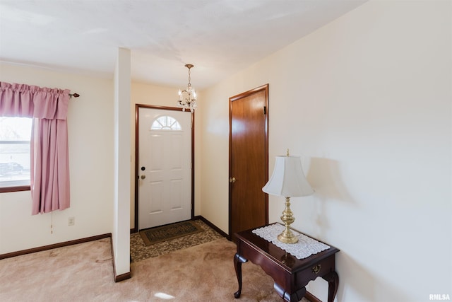 entrance foyer featuring an inviting chandelier, light colored carpet, and a wealth of natural light