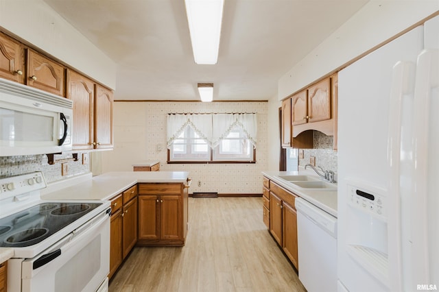 kitchen with sink, white appliances, light hardwood / wood-style flooring, decorative backsplash, and kitchen peninsula