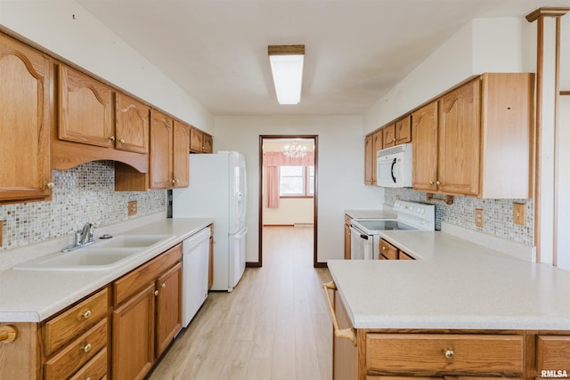 kitchen featuring tasteful backsplash, white appliances, light hardwood / wood-style floors, and sink