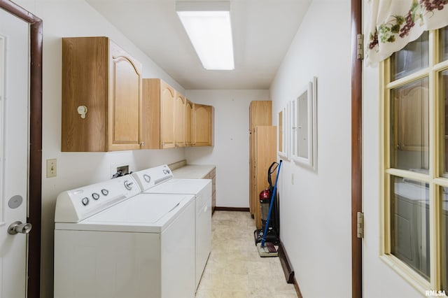 laundry room featuring separate washer and dryer and cabinets