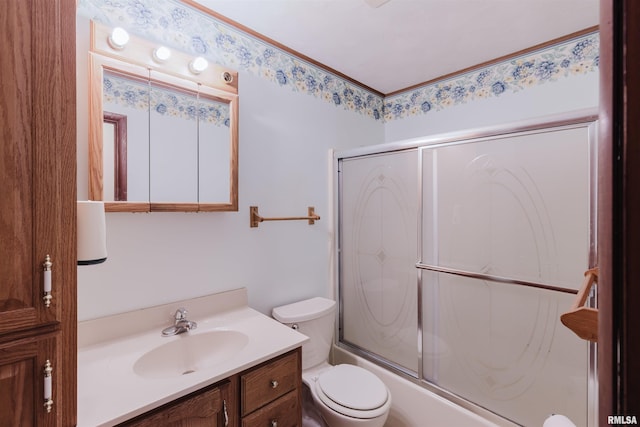 full bathroom with enclosed tub / shower combo, vanity, and toilet