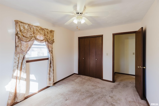 unfurnished bedroom featuring light carpet, ceiling fan, and a closet