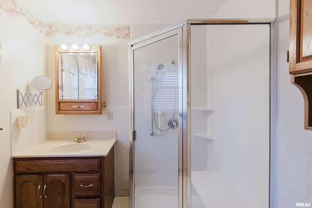 bathroom with vanity, tile walls, and walk in shower