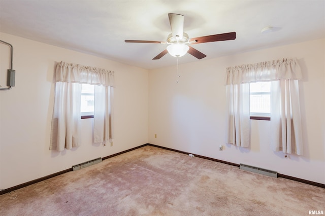 empty room with ceiling fan and light carpet