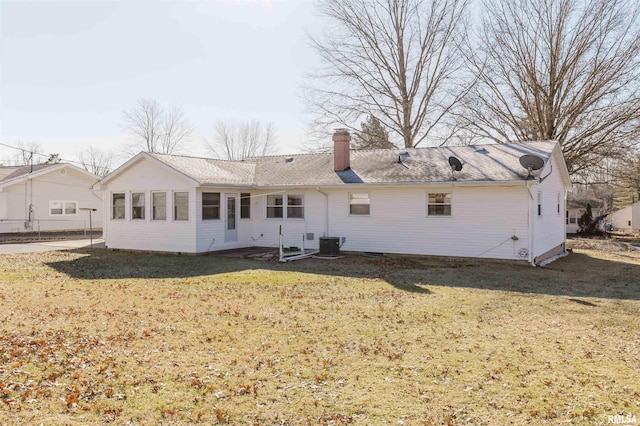 rear view of house with a lawn and central air condition unit