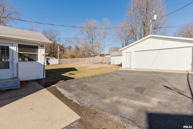 view of yard with a garage and an outbuilding