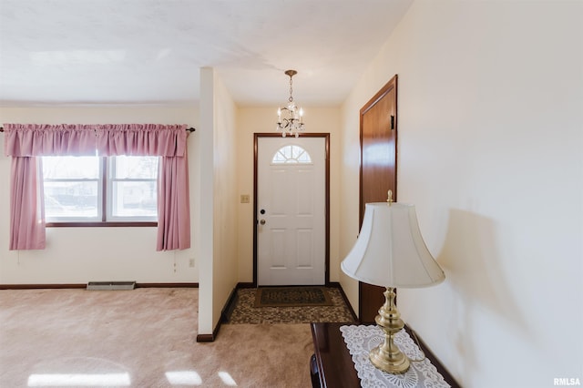 foyer entrance featuring light carpet and a notable chandelier