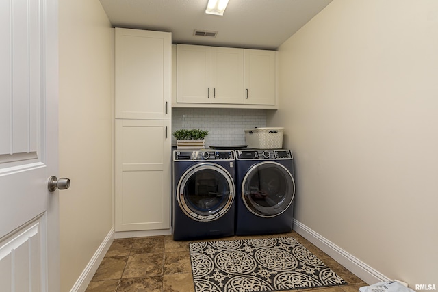 washroom featuring cabinets and washer and dryer