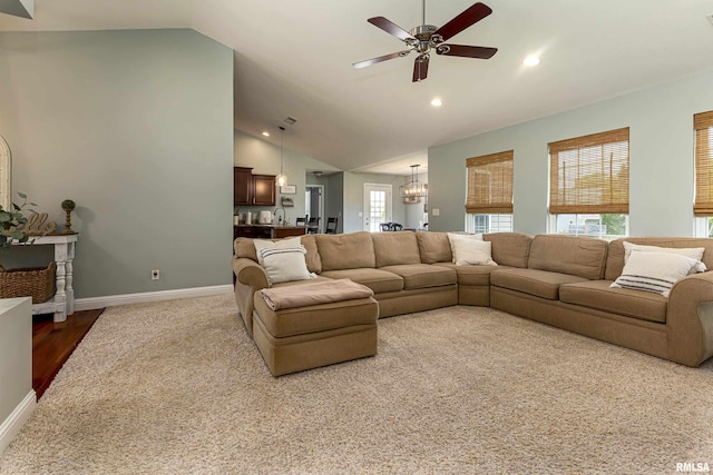 living room with high vaulted ceiling and ceiling fan with notable chandelier