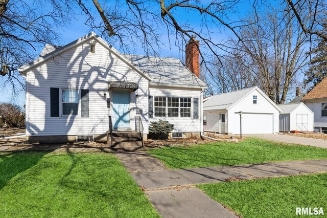 view of front of house featuring a garage, an outdoor structure, and a front yard