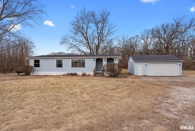 view of front of property with a garage, an outdoor structure, and a front yard