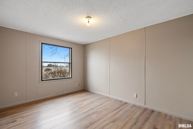 spare room with light hardwood / wood-style flooring and a textured ceiling