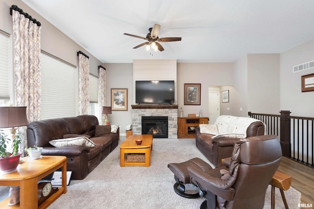 living room featuring ceiling fan and a fireplace