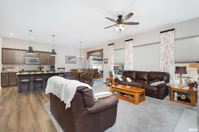 living room with light hardwood / wood-style flooring and ceiling fan