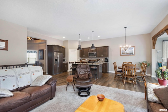 living room with dark wood-type flooring and a chandelier