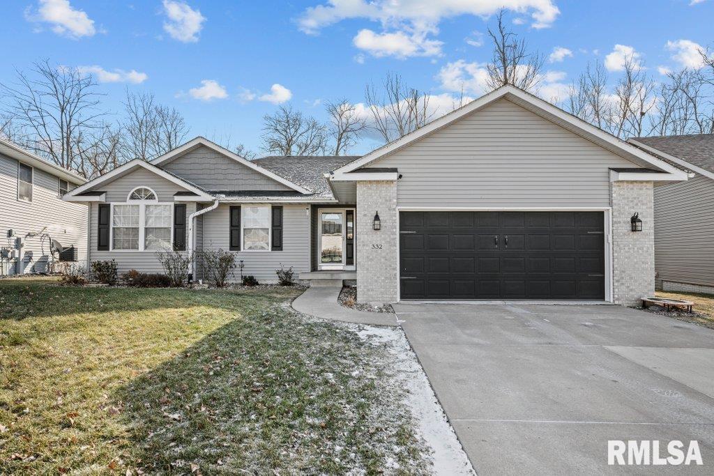 ranch-style home featuring a garage and a front lawn