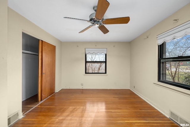 unfurnished bedroom featuring ceiling fan, light wood-type flooring, and a closet