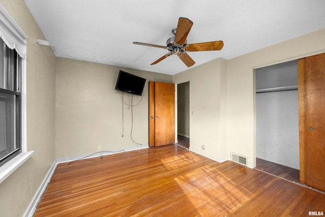 unfurnished bedroom featuring ceiling fan, hardwood / wood-style floors, and a closet