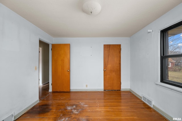 empty room with hardwood / wood-style flooring and a textured ceiling