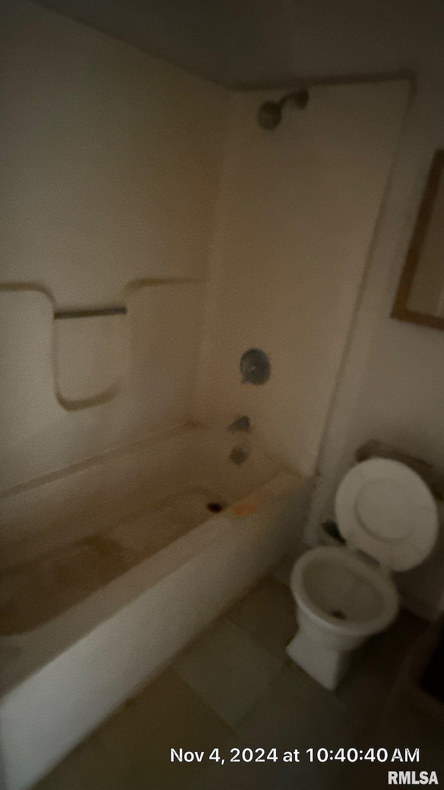 bathroom with tub / shower combination and toilet