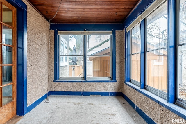 unfurnished sunroom with wooden ceiling