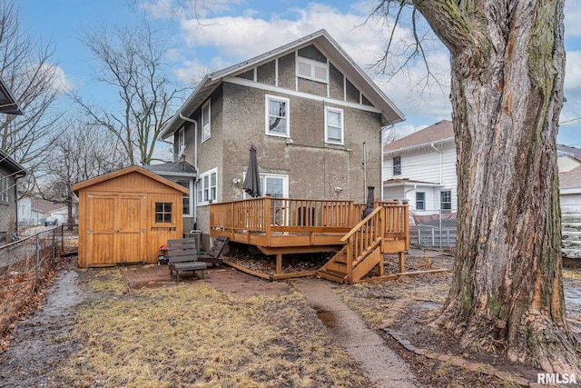 rear view of property with a wooden deck and a shed