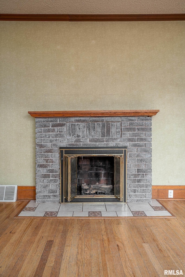 interior details featuring crown molding, wood-type flooring, and a fireplace