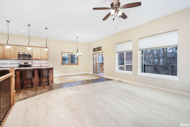 living room featuring dark hardwood / wood-style floors and ceiling fan with notable chandelier