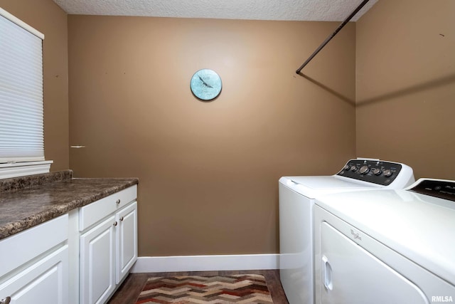 laundry room featuring washing machine and dryer, cabinets, and a textured ceiling