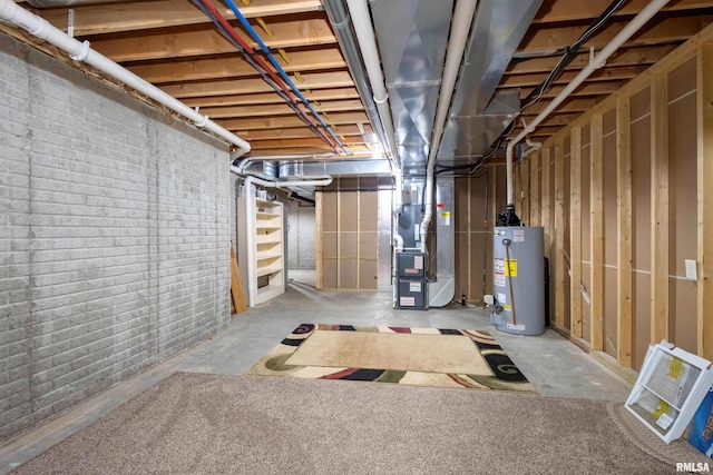 basement featuring heating unit, gas water heater, and brick wall