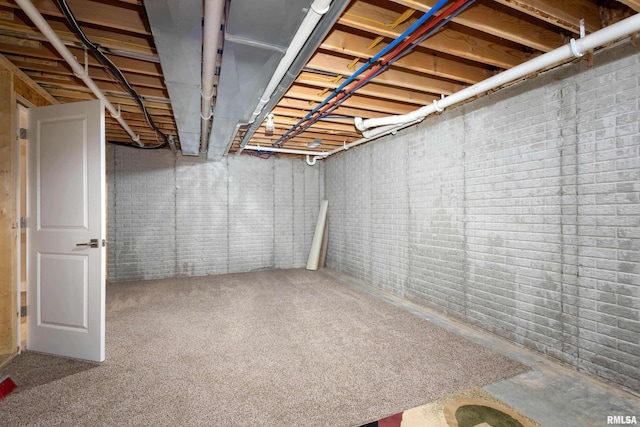 basement featuring brick wall