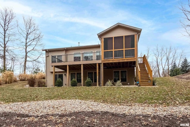 back of property featuring a yard, a deck, and a sunroom