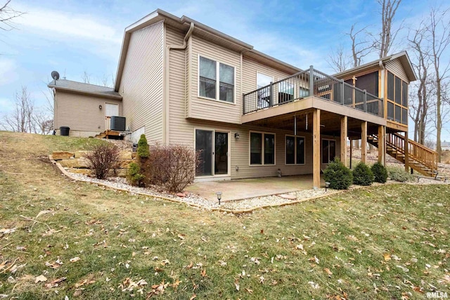 back of property with a patio, a lawn, a wooden deck, central air condition unit, and a sunroom