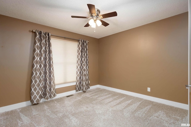 carpeted spare room with a textured ceiling and ceiling fan