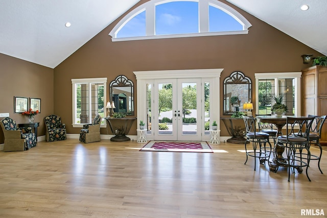 interior space featuring high vaulted ceiling, french doors, and light wood-type flooring