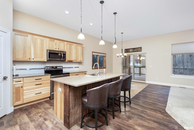 kitchen with sink, hanging light fixtures, stainless steel appliances, an island with sink, and light brown cabinetry