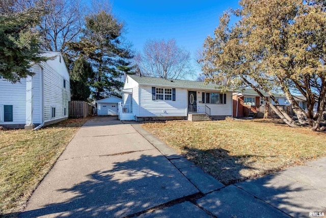 view of front facade with a garage, an outdoor structure, and a front yard