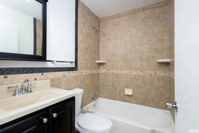 full bathroom featuring tile walls, vanity, tiled shower / bath combo, and toilet