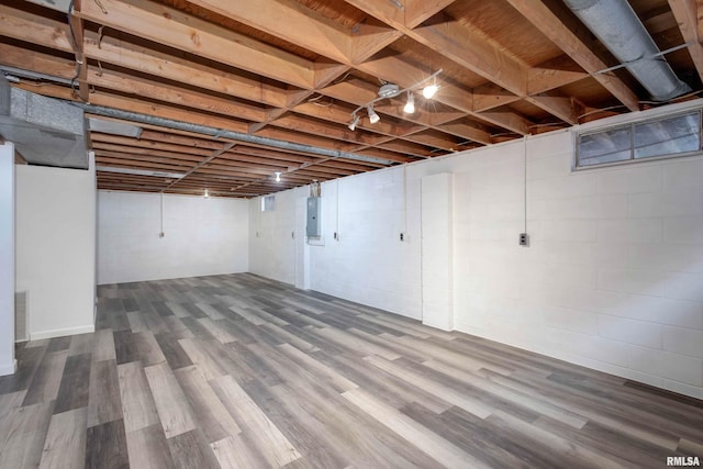 basement with hardwood / wood-style floors and electric panel