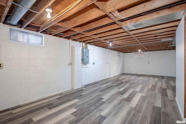 basement with hardwood / wood-style floors and electric panel