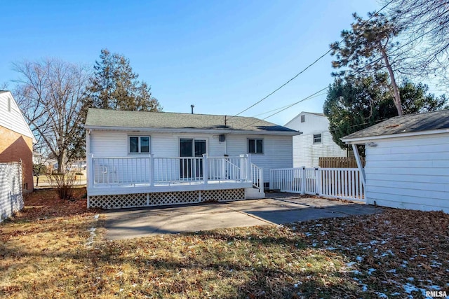 rear view of property with a wooden deck and a patio area