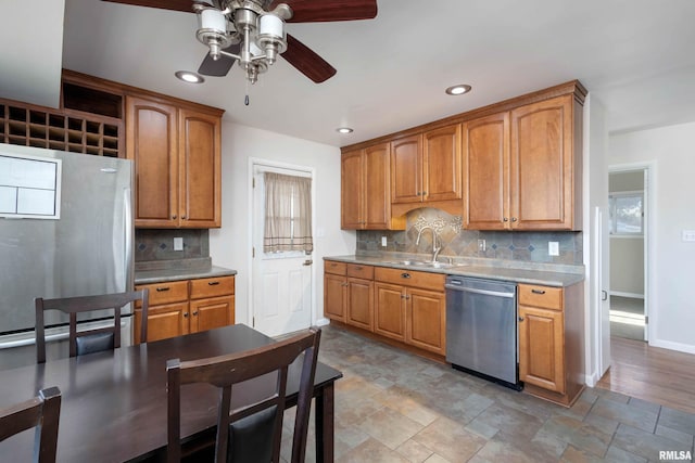 kitchen featuring stainless steel appliances, sink, backsplash, and ceiling fan