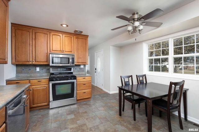 kitchen featuring stainless steel appliances, backsplash, and ceiling fan