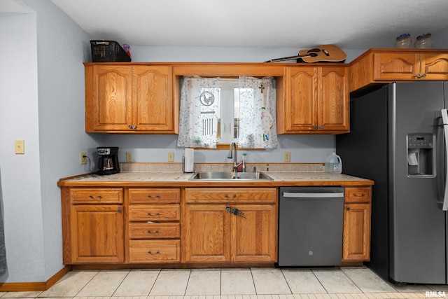 kitchen with sink, tile counters, stainless steel dishwasher, light tile patterned floors, and fridge with ice dispenser