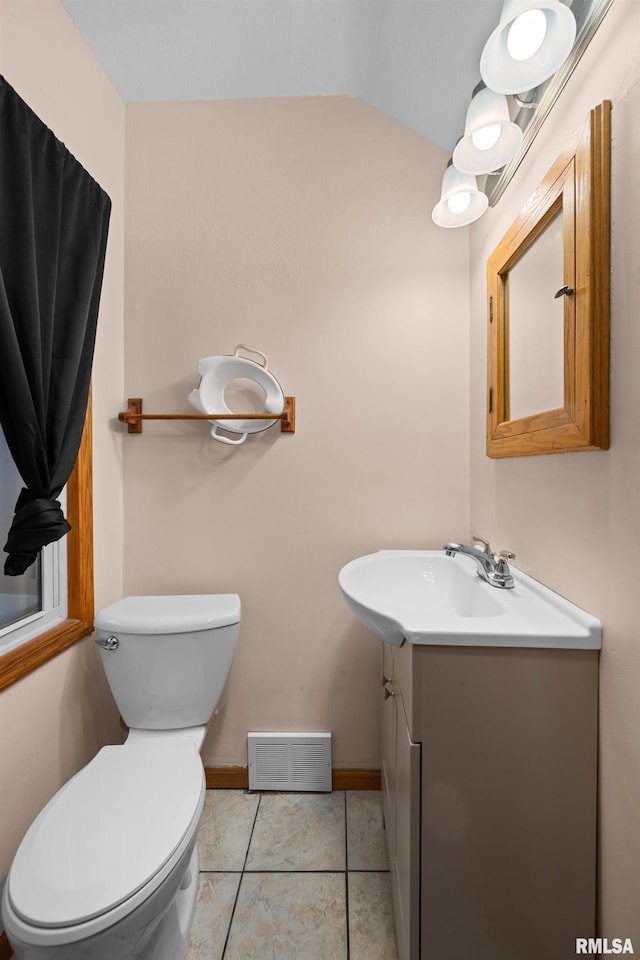 bathroom with vanity, tile patterned flooring, lofted ceiling, and toilet