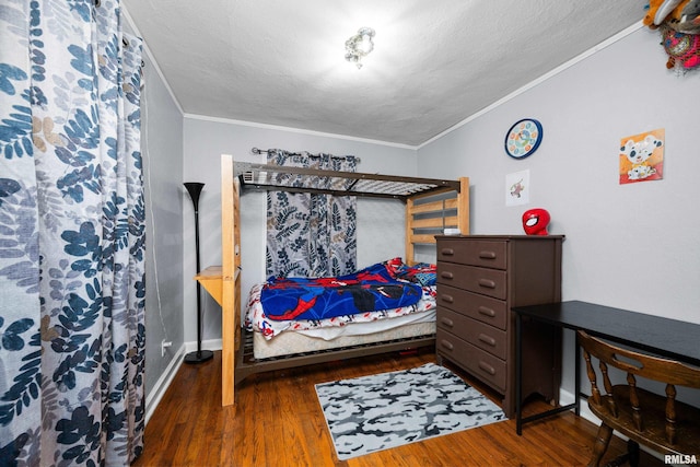 bedroom featuring crown molding, dark wood-type flooring, and a textured ceiling