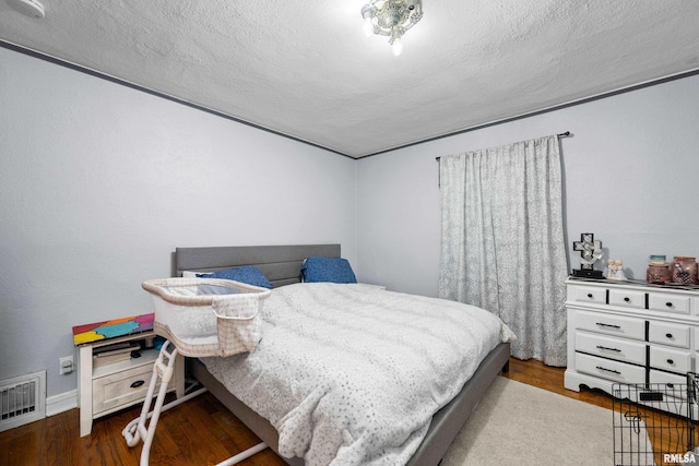 bedroom featuring hardwood / wood-style flooring and a textured ceiling