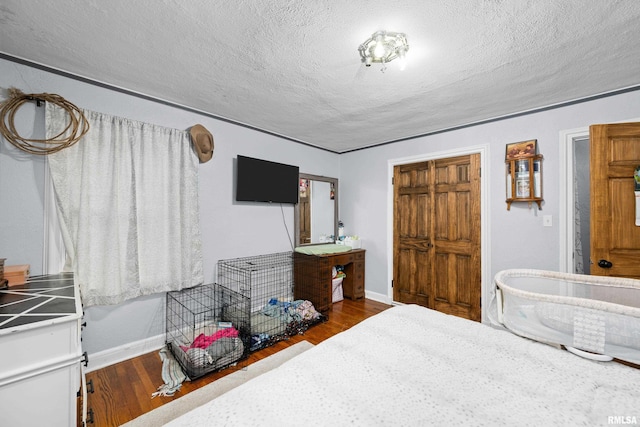 bedroom with hardwood / wood-style flooring and a textured ceiling