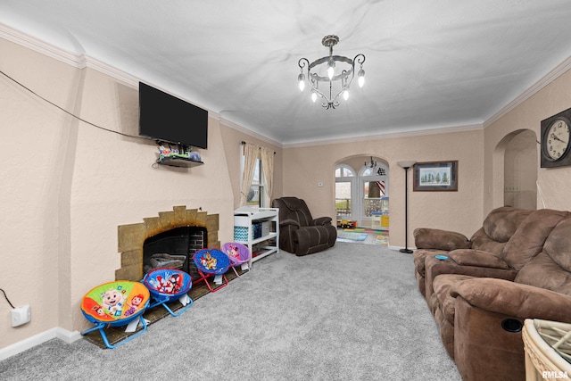 living room featuring a notable chandelier, a fireplace, ornamental molding, and carpet