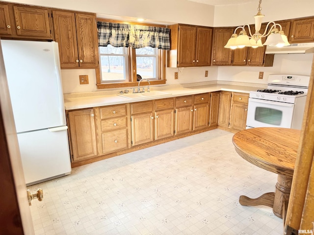 kitchen with sink, a chandelier, white appliances, and decorative light fixtures